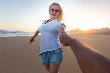 Image showing Romantic couple, holding hands,  on beach.