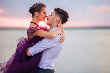 Image showing Young romantic couple relaxing on the beach watching the sunset