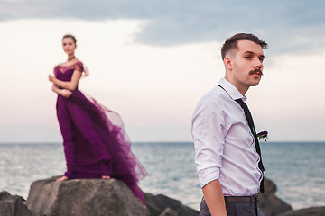 Image showing Young romantic couple relaxing on the beach watching the sunset