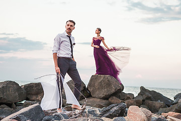 Image showing Young romantic couple relaxing on the beach watching the sunset