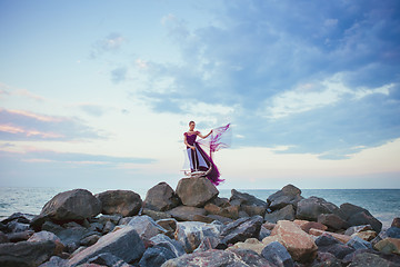 Image showing Young romantic woman posing on the beach watching the sunset