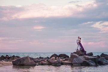 Image showing Young romantic couple relaxing on the beach watching the sunset