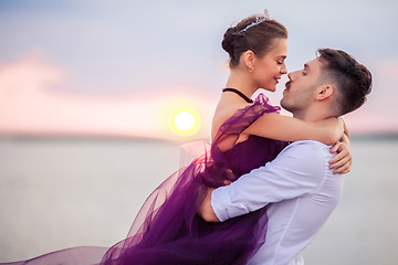 Image showing Young romantic couple relaxing on the beach watching the sunset