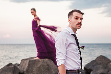 Image showing Young romantic couple relaxing on the beach watching the sunset