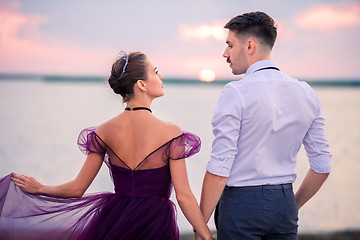 Image showing Young romantic couple relaxing on the beach watching the sunset