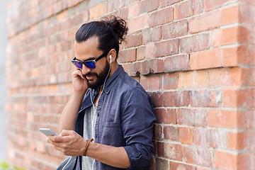 Image showing man with earphones and smartphone listening music