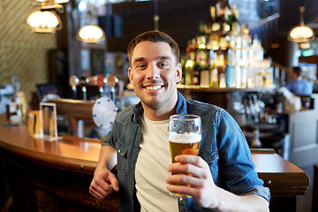 Image showing happy man drinking draft beer at bar or pub