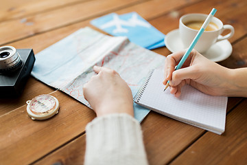 Image showing close up of traveler hands with notepad and pencil