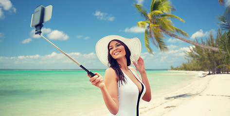 Image showing happy woman taking selfie with smartphone on beach