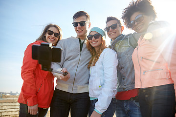 Image showing smiling friends taking selfie with smartphone