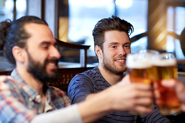 Image showing happy male friends drinking beer at bar or pub