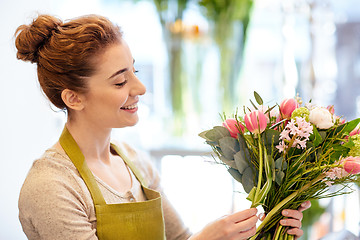 Image showing smiling florist woman making bunch at flower shop