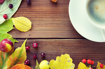 Image showing close up of coffee cup on table with autumn leaves