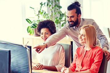 Image showing happy creative team with computer in office