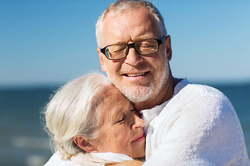 Image showing happy senior couple hugging on summer beach