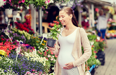 Image showing pregnant woman choosing flowers at street market