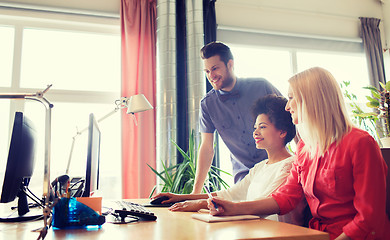 Image showing happy creative team with computer in office