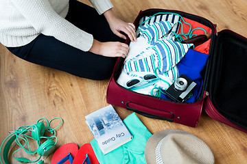 Image showing close up of woman packing travel bag for vacation