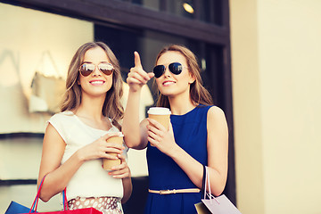 Image showing young women with shopping bags and coffee at shop