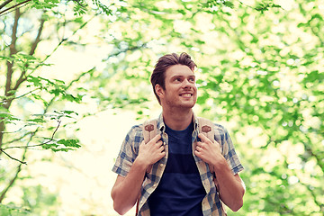 Image showing smiling young man with backpack hiking in woods