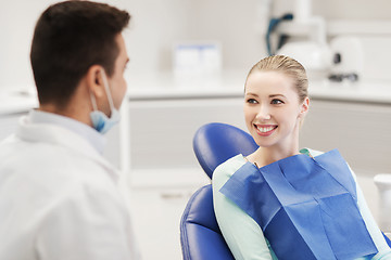 Image showing happy male dentist with woman patient at clinic