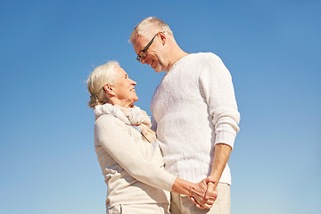 Image showing happy senior couple holding hands outdoors