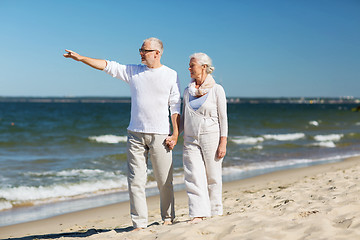 Image showing happy senior couple walking on summer beach