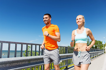 Image showing smiling couple running at summer seaside