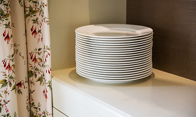 Image showing close up of plates on cupboard shelf