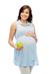 Image showing happy pregnant woman holding green apple