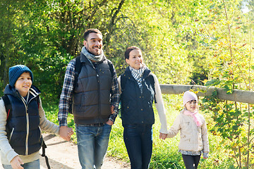 Image showing happy family with backpacks hiking in woods