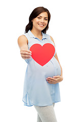 Image showing happy pregnant woman with red heart touching belly