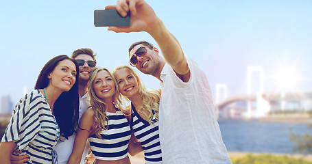 Image showing happy friends taking selfie by smartphone in tokyo