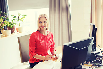 Image showing happy creative female office worker with computer