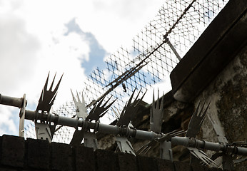 Image showing close up of fence with barbed wire and mesh