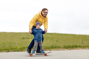 Image showing happy father and little son on skateboard