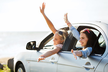 Image showing happy teenage girls or women in car at seaside