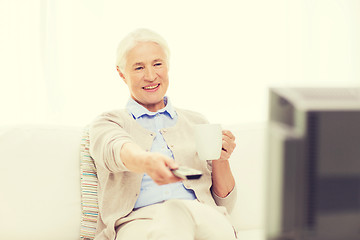 Image showing senior woman watching tv and drinking tea at home