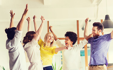 Image showing happy creative team celebrating victory in office