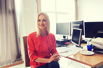 Image showing happy creative female office worker with computers