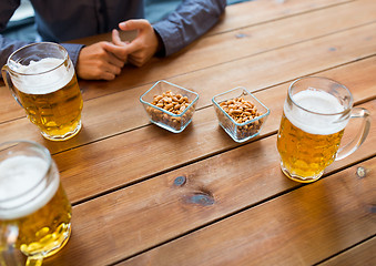 Image showing close up of hands with beer mugs at bar or pub