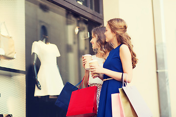 Image showing young women with shopping bags and coffee at shop