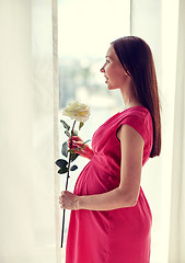 Image showing happy pregnant woman with rose flower at home