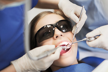 Image showing female dentists treating patient girl teeth