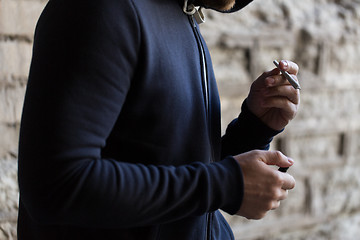 Image showing close up of addict lighting up marijuana joint