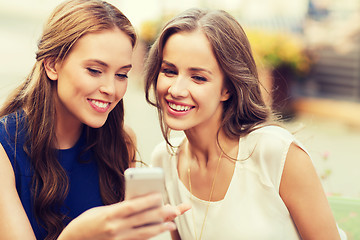 Image showing happy young women with smartphone at outdoor cafe