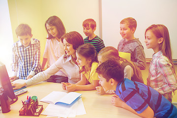 Image showing group of kids with teacher and computer at school