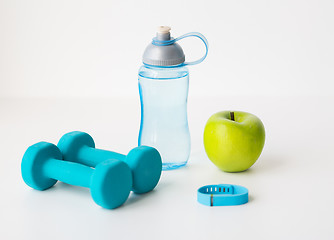 Image showing dumbbells, fitness tracker, apple and bottle