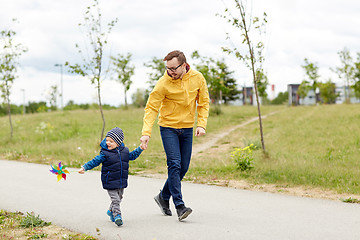 Image showing happy father and son with pinwheel toy outdoors