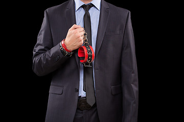 Image showing man in a business suit with leather bound. handcuffs. sex Toys